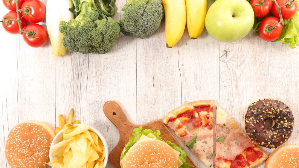 Na parte superior, frutas nutritivas, representando escolhas saudáveis. Na parte inferior, fast foods, simbolizando opções menos saudáveis.

